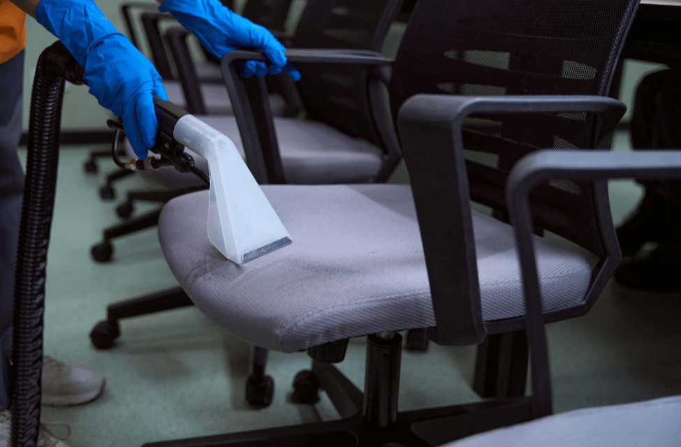 Office chair being cleaned with a vacuum cleaner